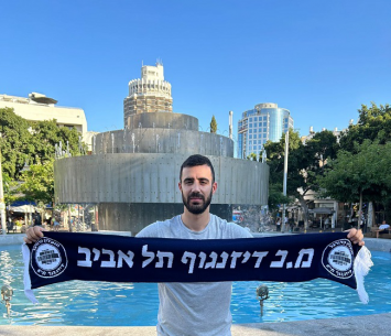 נכנס לאווירה. אביב כהן על רקע סמליו הבולטים של רחוב דיזינגוף 