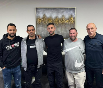 אבו עיאש (באמצע) במעמד החתימה