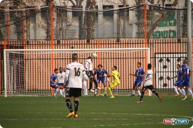 פתיחת המחצית השנייה של האורחים. דוס סנטוס נוגח לשער (צילום: קובי רוזן)